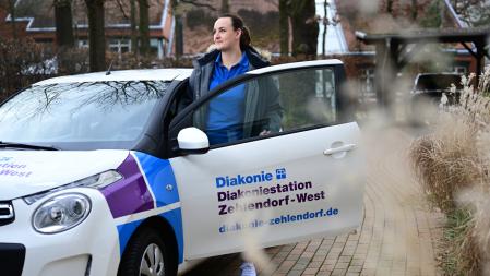 Eine Person steigt ins Auto der Diakonie-Station Zehlendorf-West