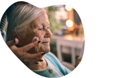 &Auml;lterer Dame wird das Gesicht eingecremt